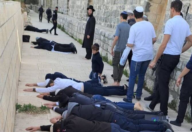 Some settlers performing the Talmudic ritual known as 'epic prostration'. (WAFA)