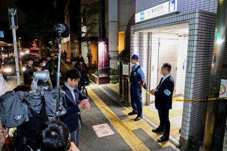 Police officers stand guard at an entrance of Todai-mae Station on Tokyo Metro's Namboku Line after a stabbing incident in Tokyo on May 7, 2025. (AFP)