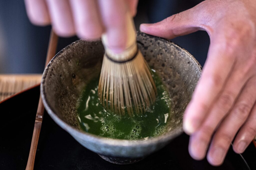 This picture taken on June 6, 2025 shows manager of Jugetsudo tea store Shigehito Nishikida making a bowl of matcha, in the shop of Tokyo's Tsukiji area. The word matcha means