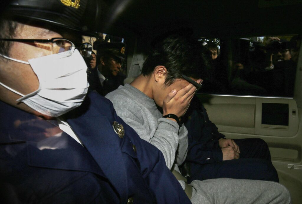 This file photo taken on November 1, 2017 shows suspect Takahiro Shiraishi (C) covering his face with his hands as he is transported to the prosecutor's office from a police station in Tokyo. Japan has executed Takahiro Shiraishi, Japanese media outlets said on June 27, 2025. (AFP)