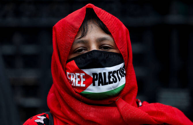 Pro-Palestinian protester wears a face mask with a message and the Palestinian flag on the day of a demonstration. (Reuters)