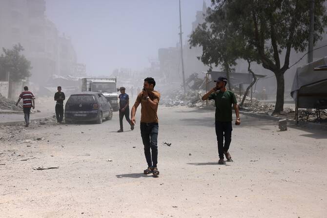 Palestinians cover their faces as they walk amid dust and smoke after an Israeli strike hit a nearby house west of Jabalia, in the northern Gaza Strip, June 1, 2025. (AFP)