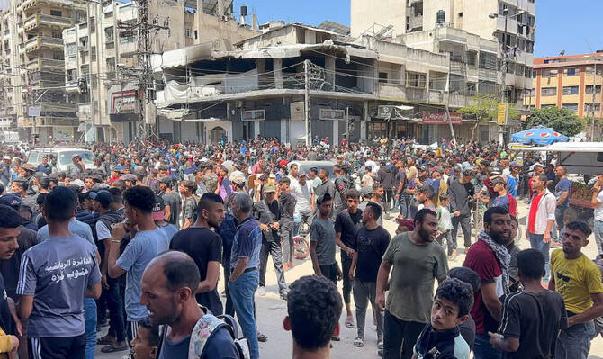 Palestinians wait to receive aid, in Gaza City, May 25, 2025. (Reuters)