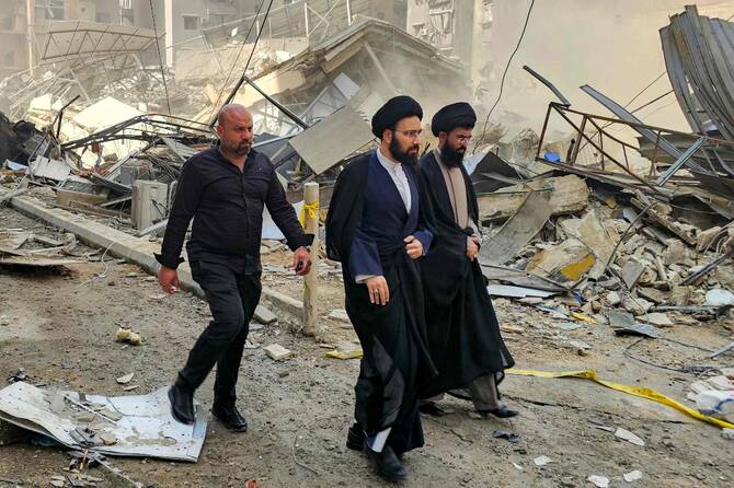 Shiite Muslim clerics walk by a collapsed building and rubble as a result of an Israeli airstrike in Haret Hreik neighbourhood, Beirut. (AFP)