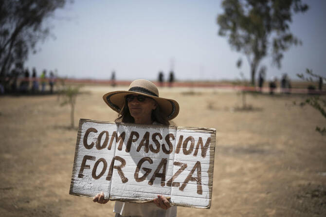 A woman holds a sign as peace activists march to call for an end to the war and starvation of civilians, near the Israel-Gaza border in southern Israel on June 6, 2025. (AP)