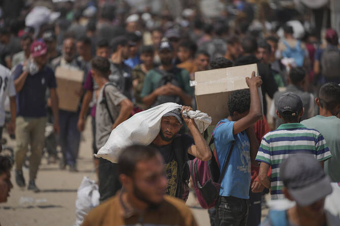Palestinians carry boxes and bags containing food and humanitarian aid packages delivered by the Gaza Humanitarian Foundation, a U.S.-backed organization approved by Israel, in Rafah, southern Gaza Strip. (AP)