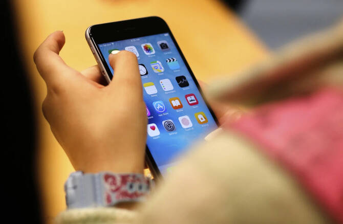 A child holds an iPhone at an Apple store in Chicago. Experts fear that smartphones have become a ‘mobile security crisis.’ (AP Photo/File)