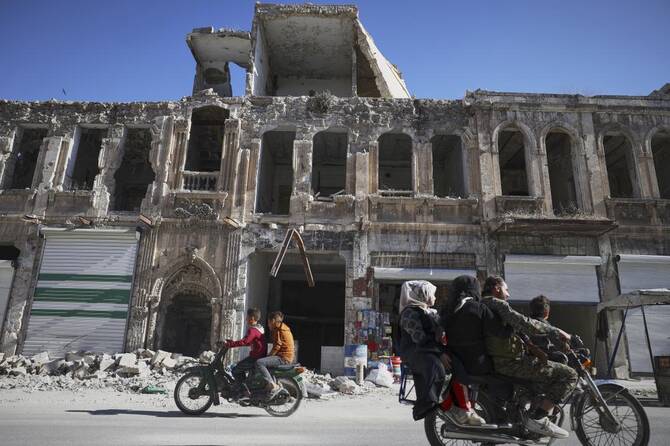 Residents drive past the war-damaged ancient market of Maarat al-Numan, near the site where a Byzantine underground tomb complex, believed to be over 1,500 years old, was uncovered by a contractor during the reconstruction of a war-damaged house, in Maarat al-Numan, Idlib suburb, Syria, on Friday, May 30, 2025. (AP)