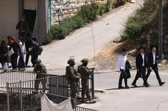 Israeli army soldiers stand guard as Ultra-Orthodox Jews visit the shrine of Atnaeil Ben Kinaz in the city of Hebron in the Israeli-occupied West Bank on April 16, 2025. (AFP)