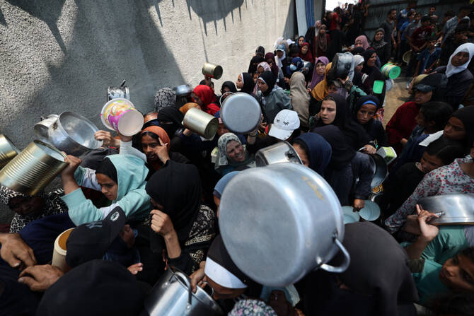 Palestinian women gather at a hot meal distribution point in Nuseirat in the central Gaza Strip, on June 4, 2025. Thousands of women in Gaza are now the heads of their households, often caring for children without adequate shelter or essential supplies. (AFP/File)