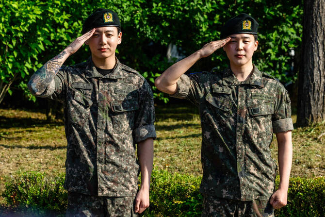 Jungkook (L) and Jimin of K-pop supergroup BTS salute for the media and fans at an outdoor sporting facility in Yeoncheon on June 11, 2025, shortly after their release from 18 months of South Korean military service. (AFP)