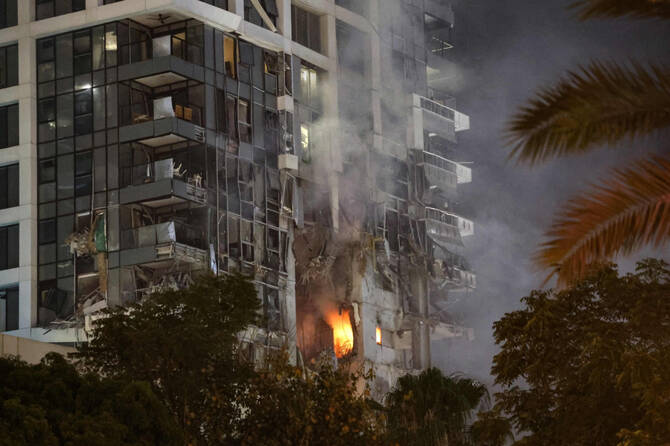 Fire and smoke rise from a building in central Tel Aviv that was hit by a missile fired from Iran on June 13, 2025. (AFP)