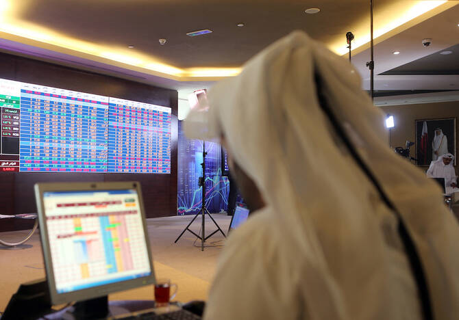 A Qatari trader follows the stock market at the Qatari stock exchange in Doha. File/AFP