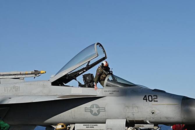 A pilot enters a F/A-18 Hornet jet as it prepares to take off from the deck of aircraft carrier USS Harry S. Truman. (AFP/File)
