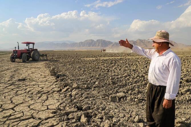 Hussein Khedr Shekha, a farmer, gestures as he speaks by a field near the village of Sarsian, at the edge of the Dukan dam reservoir in the KRG. (AFP)