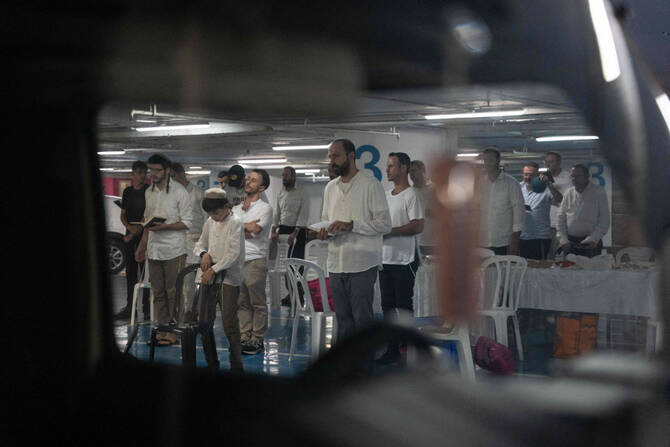 Israelis pray as they take shelter in an underground parking lot under a mall in Tel Aviv, on June 21, 2025, as the war between Israel and Iran continued for the ninth day. (AFP)
