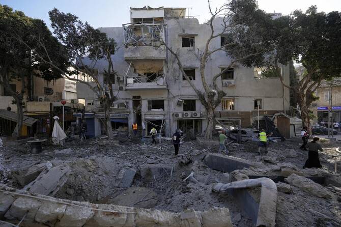 Firemen and rescue workers survey the site where a missile launched from Iran struck in Haifa, Israel on June 22, 2025. (AP)