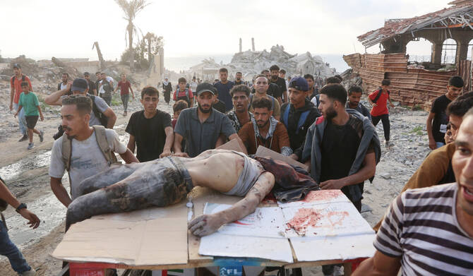 People transport the body of a man, killed as he waited for humanitarian aid, along al-Rashid street in western Jabalia on June 22, 2025, after trucks carrying humanitarian aid entered the northern Gaza Strip through the Israeli-controlled Zikim border crossing, amid the ongoing war between Israel and Hamas. (AFP)