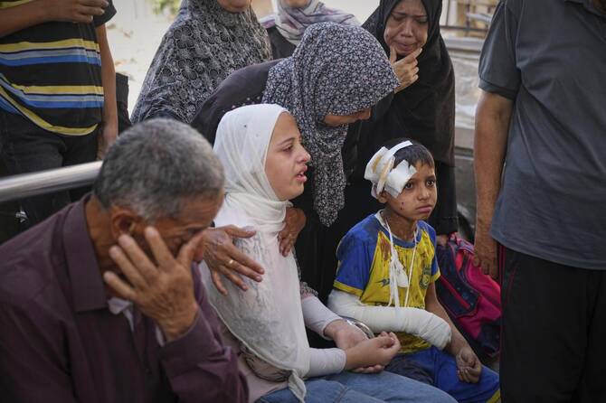 Hamam Al-Farani sits next to his sister, in white, along with other family members as the body of their father Alaa, killed in an Israeli army strike that also injured the boy, is prepared for burial at Shifa hospital in Gaza City, on Tuesday, June 24, 2025. (AP)