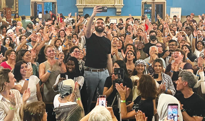 Palestinian photographer and Instagram star Motaz Azaiza takes a selfie among the crowd at a charity fundraiser at the First Unitarian Church of Philadelphia in Pennsylvania. (AFP)