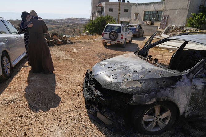 Women comfort each other after Israeli settlers attacked the West Bank village of Kafr Malik, leaving three Palestinians killed. (AP)