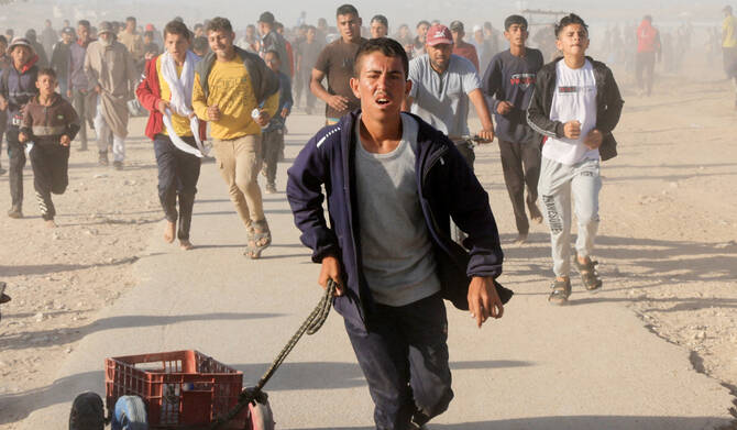 Palestinians walk to collect aid supplies from the U.S.-backed Gaza Humanitarian Foundation, in Khan Younis. (REUTERS)