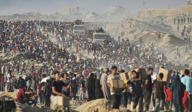 Palestinians carry sacks and boxes of food and humanitarian aid that was unloaded from a World Food Program convoy in Gaza. (AP)