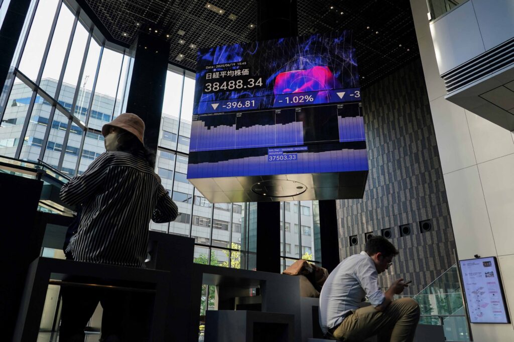 An electronic board (top) shows the closing numbers of the Nikkei Stock Average on the Tokyo Stock Exchange in Tokyo on June 19, 2025.(AFP)