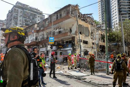 First responders walk outside a heavily-damaged building at the site of an Iranian missile attack in Ramat Gan in central Israel near Tel Aviv, on June 19, 2025. (AFP)