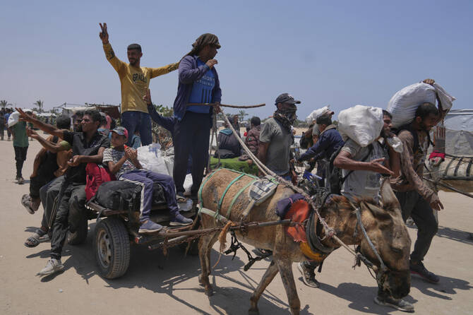 Palestinians carry bags containing food and humanitarian aid packages delivered by the Gaza Humanitarian Foundation, a U.S.-backed organization, in Rafah, southern Gaza Strip, Tuesday, June 10, 2025. (AP Photo/Abdel Kareem Hana)