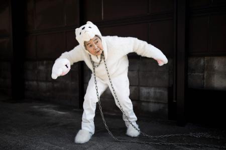 This file picture taken on January 16, 2018 shows Kimiko Nishimoto, dressed in a dog costume, gesturing during a self photo shoot outside her house in the western Japanese city of Kumamoto. (AFP)