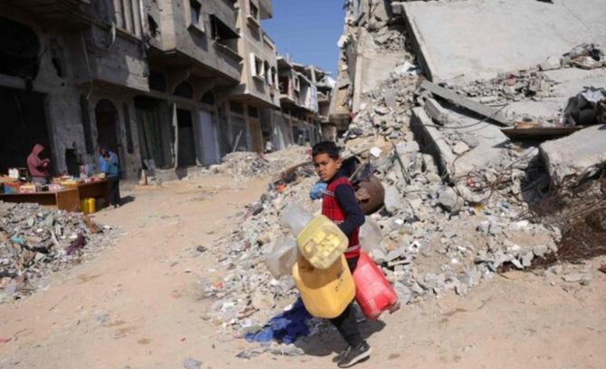 A Palestinian boy walks to a potable water collection point in Jabalia, northern Gaza Strip. (AFP)