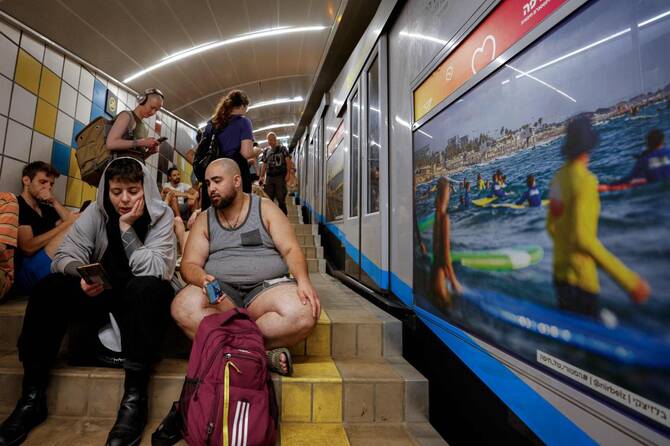 People take shelter at a station of the Carmelit underground funicular railway in Israel’s northern city of Haifa on Jun. 17, 2025 amidst fears of an Iranian missile attack. (AFP)