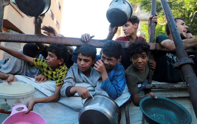 Palestinians react as they ask for food from a charity kitchen, amid a hunger crisis, in Gaza City, July 7, 2025. (Reuters)