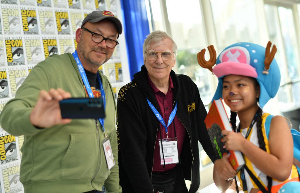 (L/R) Authors Steve Ryfle and Ed Godziszewski pose with a young fan at the signing of their book