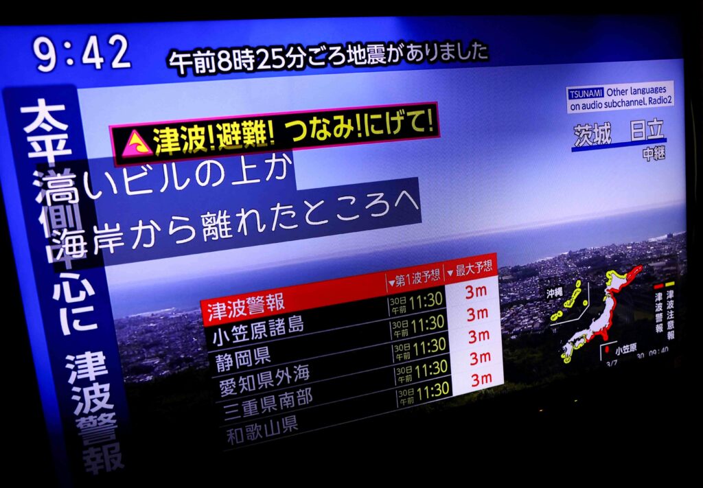 A television screen shows a news report on Japan Weather Agency's tsunami warning, saying it expected tsunami waves of up to 3 meters (10 feet) to reach large coastal areas in Japan after a powerful earthquake struck off Russia's Far Eastern Kamchatka Peninsula, in Tokyo, Japan July 30, 2025. REUTERS
