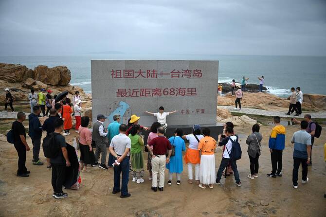 People take photos in front of the Taiwan Strait at a tourist spot called ‘68 Nautical Miles’ on Pingtan island, the closest point in China to Taiwan’s main island, on May 24, 2024. (AFP)