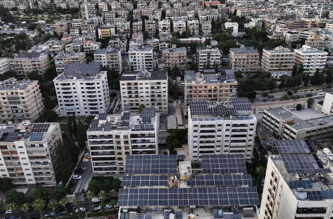 An aerial view shows solar panels installed on building rooftops in Damascus, Syria, Monday, June 30, 2025. (AP Photo/Ghaith Alsayed)