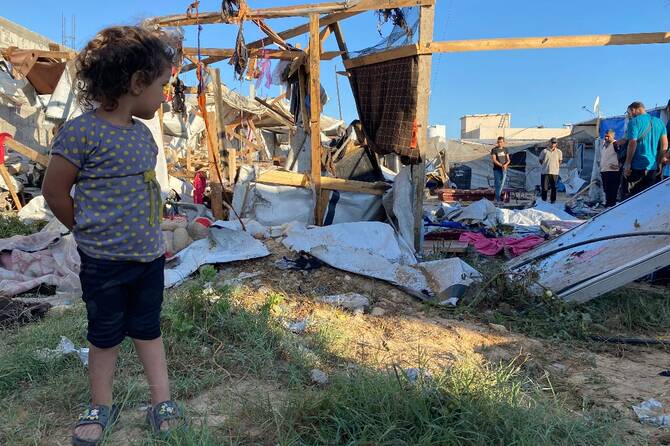 A displaced Palestinian girl looks on the damage inflicted by an Israeli airstrike in Gaza City. (AFP)