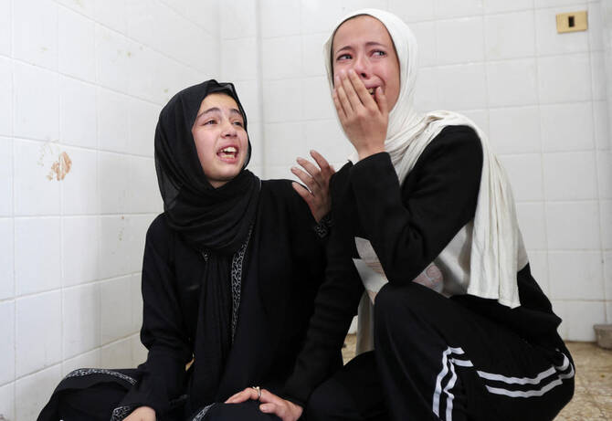 Palestinians react as casualties are brought into Al-Aqsa Martyrs Hospital following an Israeli strike, in Deir Al-Balah, central Gaza on Thursday. (Reuters)