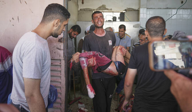 Fadi Al-Nouri carries the body of his 11-year-old nephew Omar, who was among 10 people, including two women and five children, killed in an Israeli strike while they were waiting to receive nutritional supplements at a Project Hope-run medical clinic in Deir al-Balah, Gaza Strip, Thursday, July 10, 2025. (AP)