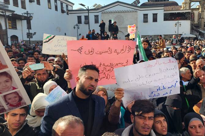 Syrians raise placards during a demonstration calling for the release of Syrian political prisoners in Lebanon, reportedly being detained due to their opposition to the toppled Assad regime, outside the Umayyad mosque in Damascus on January 3, 2025. (AFP)