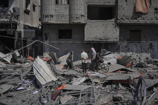 Palestinians inspect the wreckage of a gas station destroyed in an Israeli airstrike in Deir Al-Balah, central Gaza Strip on July 12, 2025. (AP)