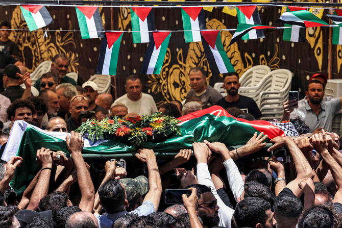 Mourners carry the body of Palestinian Mohammad Al-Shalabi, killed by Israeli settlers, during his funeral in the Palestinian village of Al-Mazraa Al-Sharqiya in the occupied West Bank on July 13, 2025. (AFP)