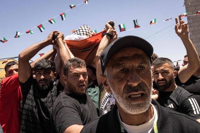 Mourners carry the body of dual US-Palestinian citizen Sayfollah Musallet during his funeral at Al-Mazraa Al-Sharqiya in the occupied West Bank on July 13, 2025, after he was killed by Israeli settlers two days prior. (AFP)
