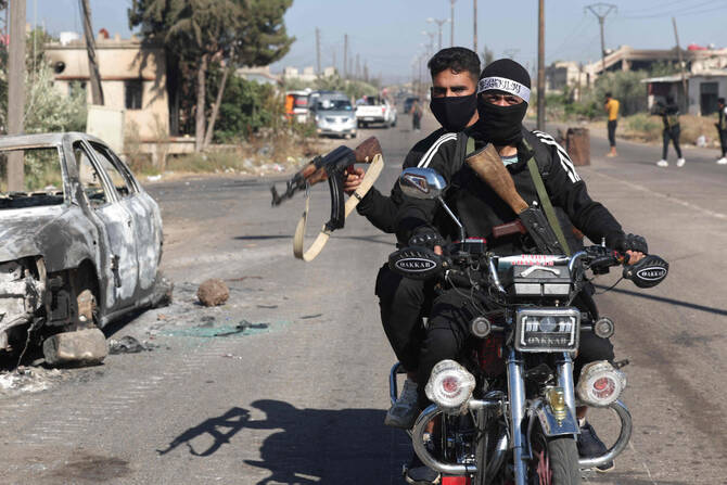 Tribal and Bedouin fighters cross the al-Dur village in Syria's southern Sweida governorate as they mobilize amid clashes with Druze gunmen on July 18, 2025. (AFP)