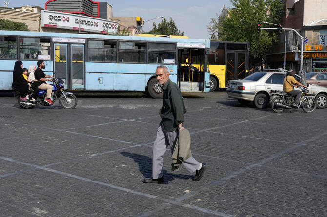 A man crosses an intersection on a hot summer day in downtown Tehran, Iran, Monday, July 21, 2025. (AP)