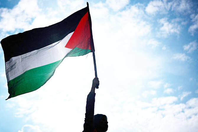 A protester holds a Palestinian flag during a rally called by several French organizations in support of Palestinian people at Place de la Republique in Paris on May 7, 2024. (AFP)