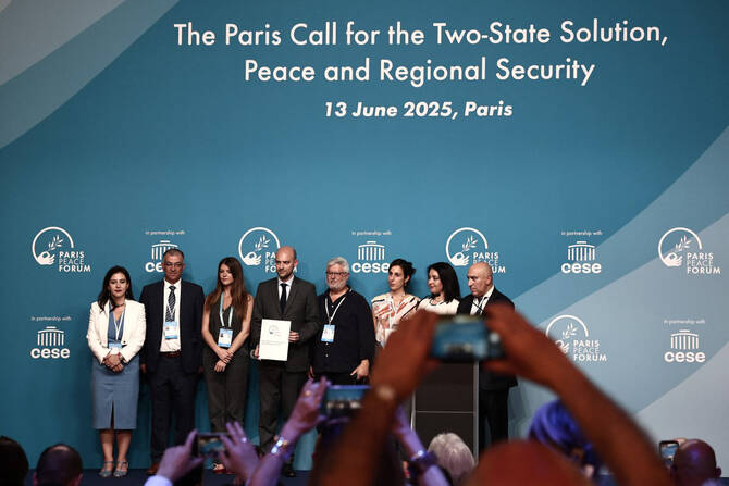 France's Minister for Europe and Foreign Affairs Jean-Noel Barrot (C) pose with participants during a conference dubbed 