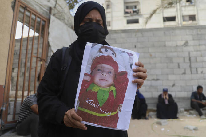 Esraa Abu Halib shows to journalists a photo of her 5-month-old baby, Zainab, who died from malnutrition-related causes, according to the family and the hospital, as she stands outside the Nasser Hospital, in Khan Younis, July 26, 2025. (AP)
